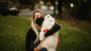 Pet sitter wearing gloves and mask while caring for a dog in Columbus, Ohio.
